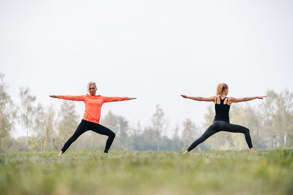 Two persons in warrior pose yoga Virabhadrasana
